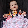 baby, smiling, blanket, floral_pattern, stroller, child, clothing, happy, infant, seated, cute, portrait, toddler, warm, comfort, baby_girl, face, expression, indoors, soft