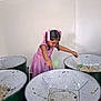 Ravisha is registered to the contest to win money with this photo: child, girl, braids, pink_ribbons, pink_dress, steel_drums, musical_instruments, indoor, white_wall, green_drums, playing, music, hands, stick, concentration, young, person, activity, cultural, performance