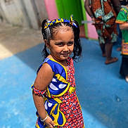 Ravisha joined the competition — help win amazing prizes! child, girl, colorful_dress, headband, standing, outdoor, blue_floor, people, background_blur, smiling, portrait, sunlight, patterned_clothing, hair_tied, accessories, happy, casual, vibrant_colors, person, fashion