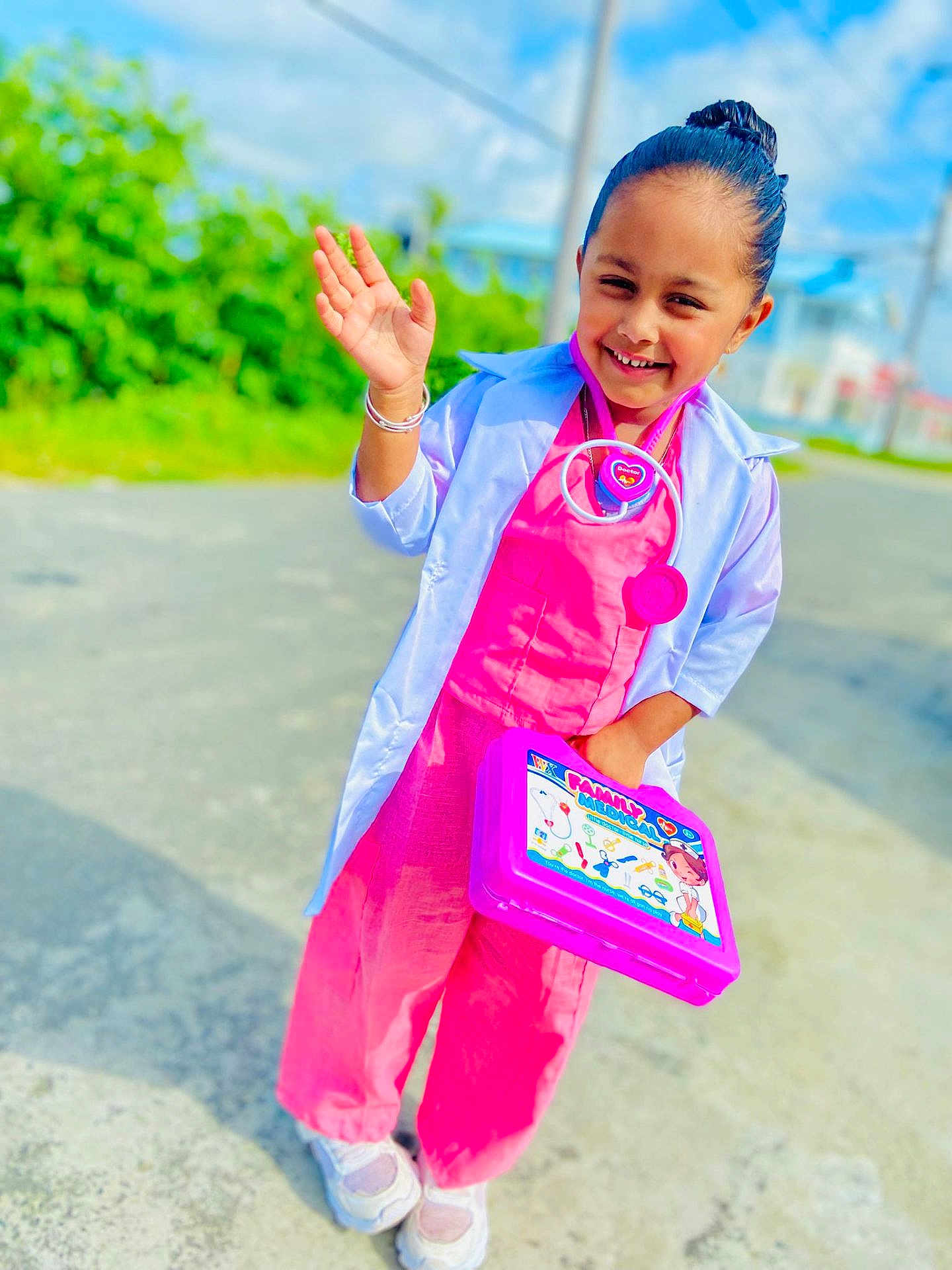 Ravisha joined the competition — help win amazing prizes! child, girl, smiling, toy, doctor_costume, pink_clothing, white_coat, stethoscope, medical_kit, outdoor, daylight, sidewalk, greenery, happy, posing, casual_shoes, play, young, portrait, fun