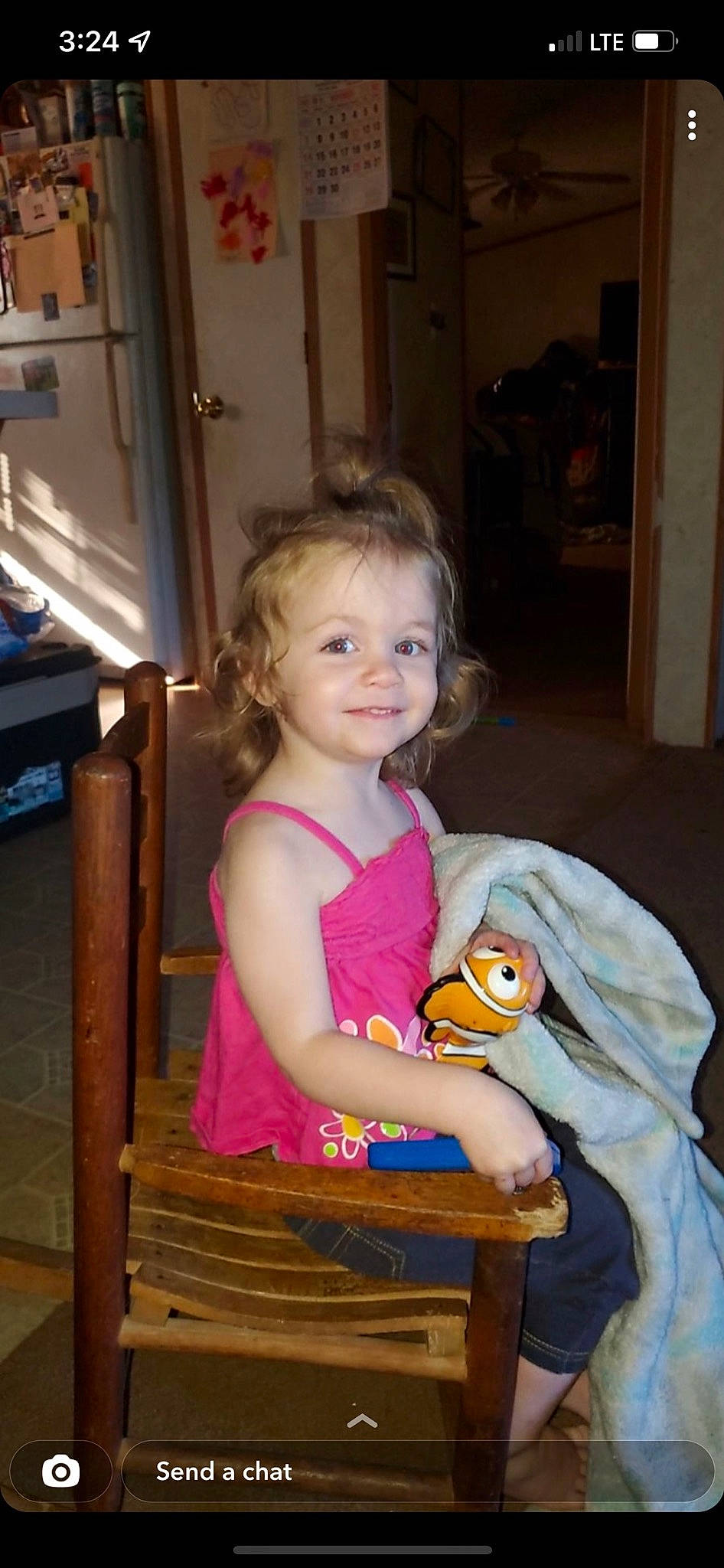 Ember is registered to the contest to win money with this photo: baby_toddler_clothing, blond, chair, child, event, eye, facial_expression, flooring, fun, happy, iris, joy, organ, person, room, sitting, smile, standing, t_shirt, toddler