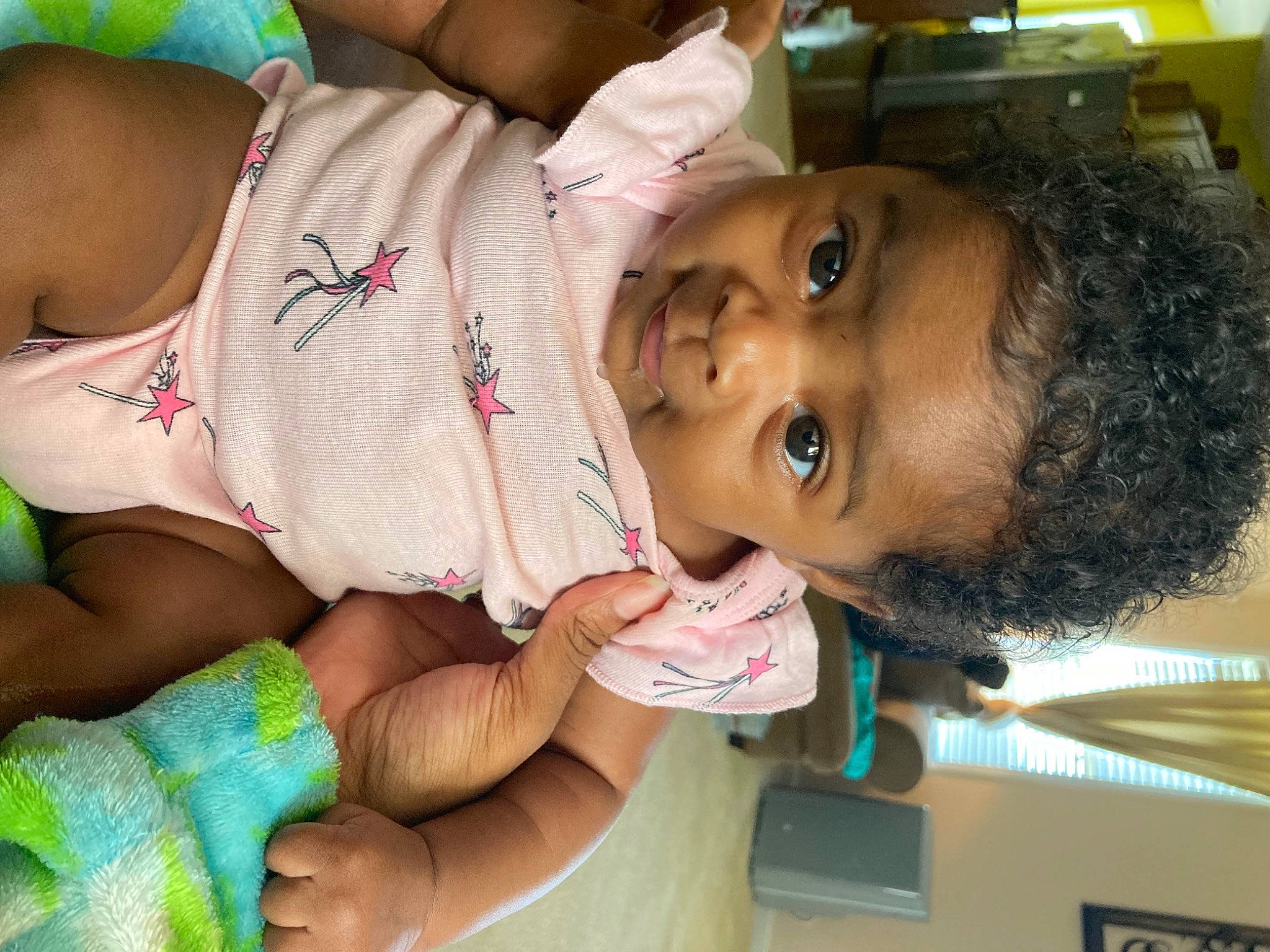 Charlie is registered to the contest to win money with this photo: arm, baby, black_hair, cheek, eyelash, facial_expression, finger, fun, green, hand, happy, human, lip, mouth, nose, organ, person, skin, smile, thigh