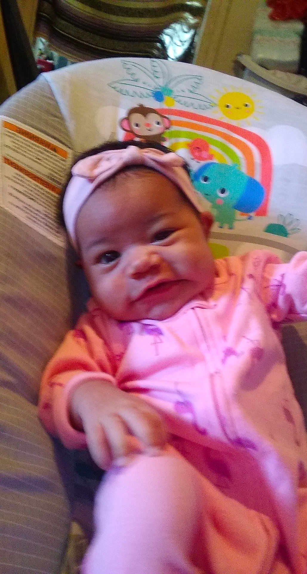Billie joined the competition — help win amazing prizes! baby, infant, pink_clothing, headband, bow, baby_chair, cartoon_animals, monkey, elephant, sun, colorful, indoor, child, face, hand, cute, smile, portrait, young_child, cozy