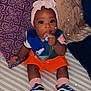 Kennedi is registered to the contest to win money with this photo: baby, bodypart, bonnet, cap, clothing, couch, face, finger, footwear, furniture, hand, hat, head, person, photography, portrait, shoe, sitting, sneaker, toy
