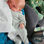 Zachariah is registered to the contest to win money with this photo: baby, newborn, infant, striped_pajamas, blanket, couch, baby_bottle, thermos, green_pillow, floral_pattern, hand, footed_pajamas, face, person, indoor, cozy, resting, cute, sleepy, soft