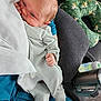 baby, newborn, infant, striped_pajamas, blanket, couch, baby_bottle, thermos, green_pillow, floral_pattern, hand, footed_pajamas, face, person, indoor, cozy, resting, cute, sleepy, soft