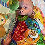 Elijah joined the competition — help win amazing prizes! baby, infant, toy, plush_toy, colorful, playmat, chewing, curious, child, cute, soft_toy, patterned, fabric, indoor, person, face, head, hand, play, bright