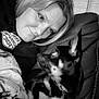 woman, dog, black_and_white, couch, blanket, portrait, indoor, pet, face, leisure, comfort, closeup, furniture, canine, snuggle, relaxation, expression, hair, clothing, seated