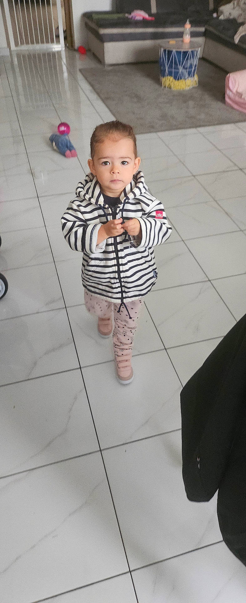 Olivia participe au concours pour gagner de l'argent avec cette photo : baby, bodypart, clothing, coat, cutlery, face, finger, footwear, hand, head, jacket, longsleeve, pants, person, photography, portrait, shoe, sleeve, spoon, tile