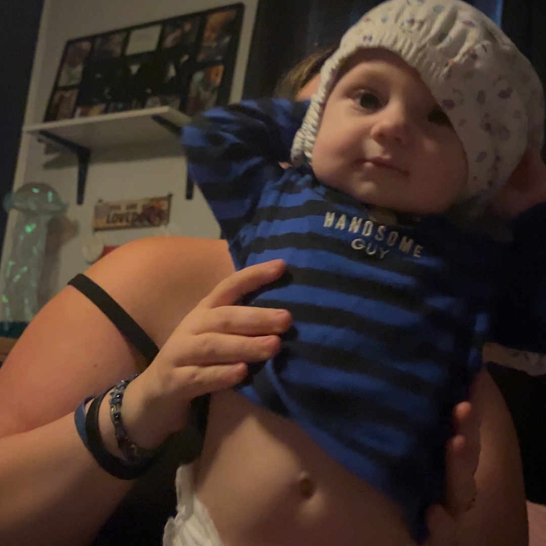 Nashton joined the competition — help win amazing prizes! adult, baby, casual, child, curtains, diaper, dim_light, expression, face, hand, headwear, holding, home, indoor, person, photoframe, room, shelf, shirt, striped_clothing