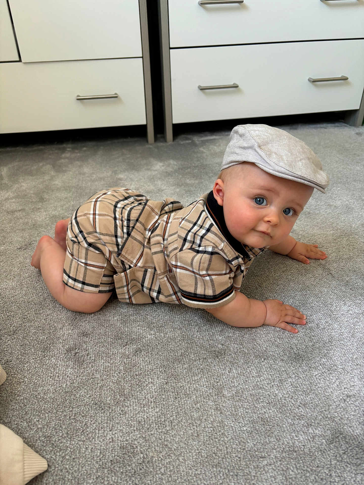 Luca joined the competition — help win amazing prizes! baby, child, crawling, plaid_clothing, cap, carpet, indoor, furniture, drawer, blue_eyes, cute, infant, person, floor, headwear, skin, hand, foot, expression, portrait