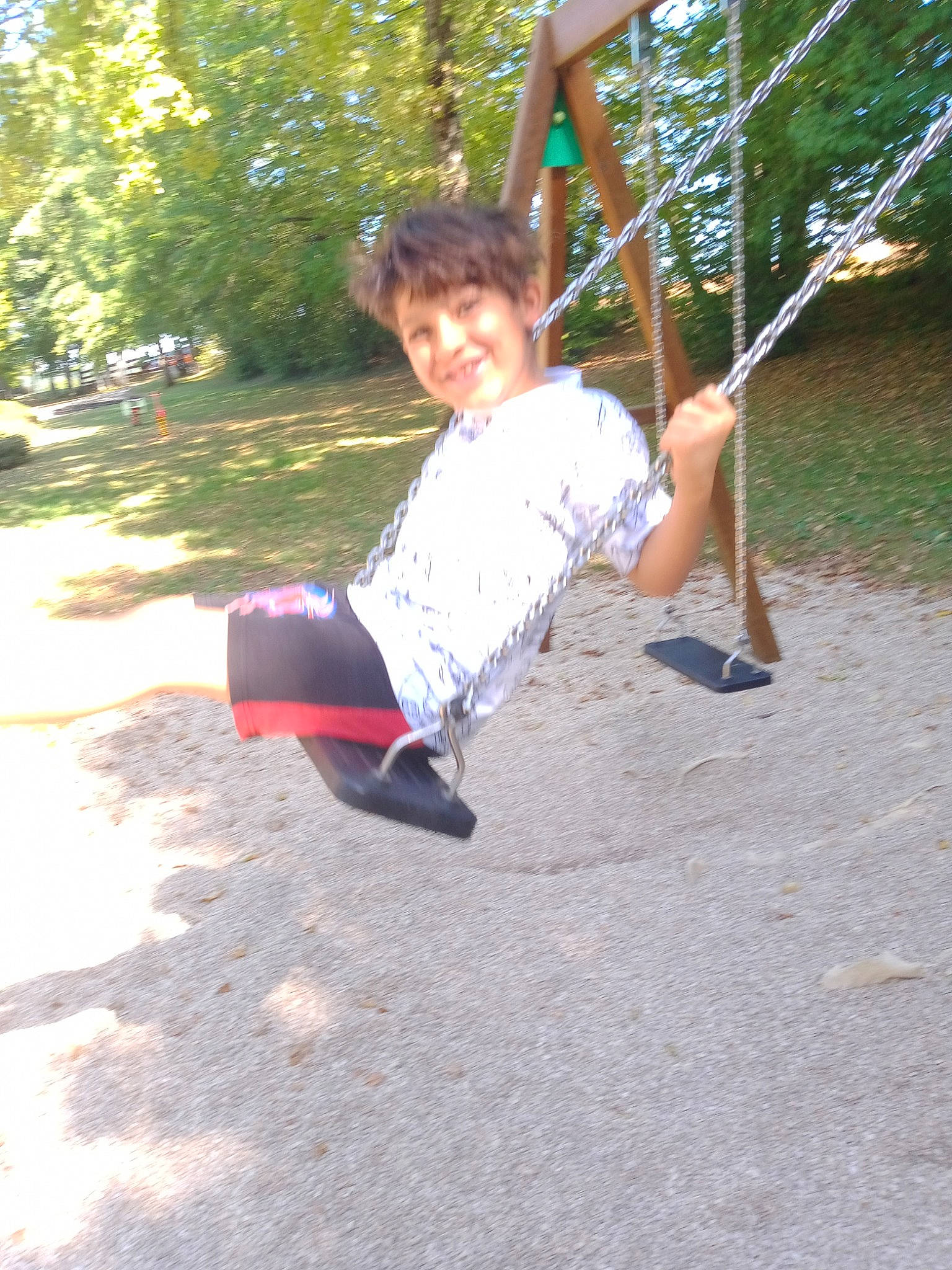 Iyèd a rejoint le concours — aidez-le/la à gagner de superbes lots ! balance, child, city, fun, grass, happy, joy, leisure, outdoor_play_equipment, person, plant, play, playground, recreation, shorts, sitting, sleeve, smile, swing, t_shirt