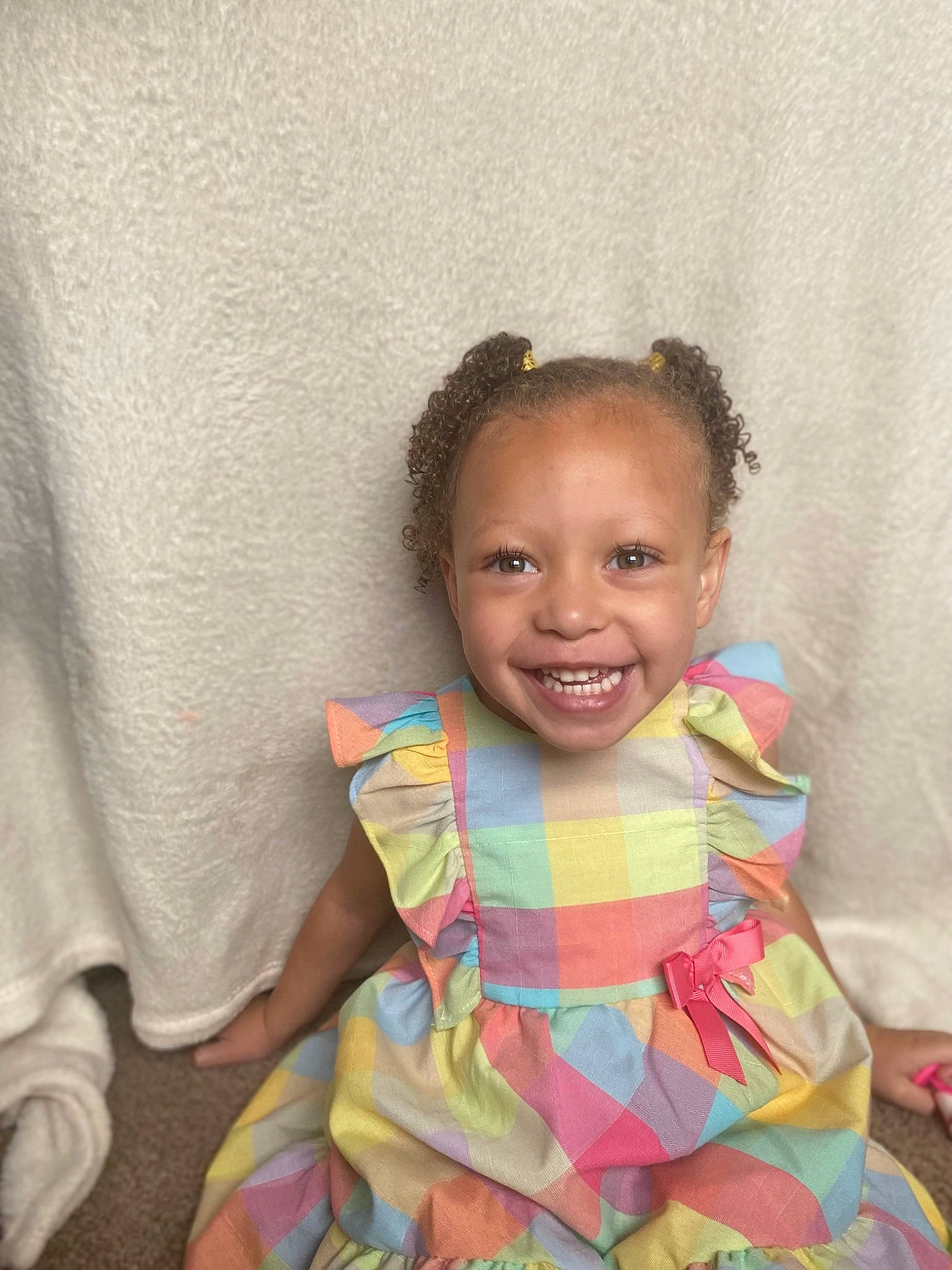 Londyn is registered to the contest to win money with this photo: baby, baby_toddler_clothing, cheek, child, eye, fashion_design, fun, happy, head, iris, jewellery, joy, linens, pattern, person, pink, room, sitting, skin, smile