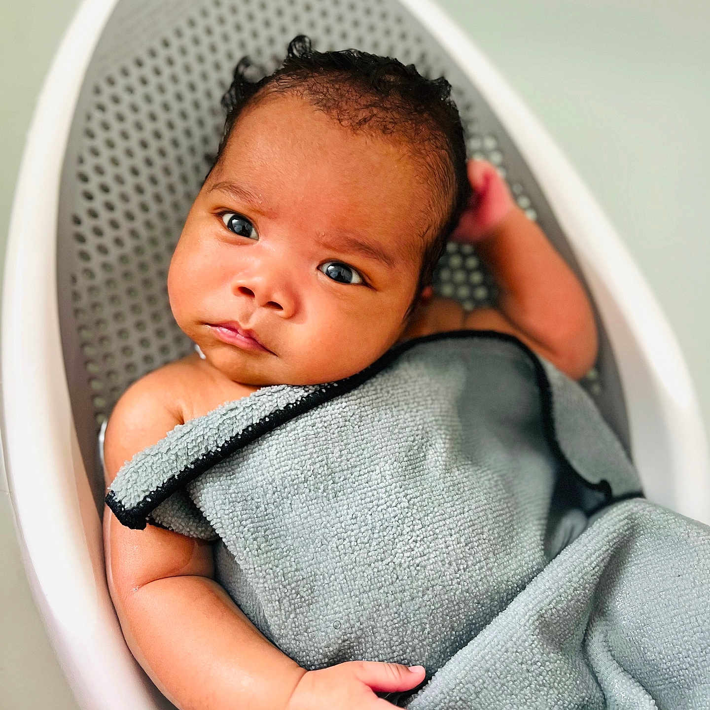 Harrison is registered to the contest to win money with this photo: baby, bathing, blanket, crib, face, furniture, happy, head, infantbed, newborn, person, photography, portrait, smile, towel