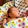 Madison is registered to the contest to win money with this photo: baby, sleeping, blanket, floral_pattern, hand, quilt, bed, cozy, infant, peaceful, skin, newborn, resting, comfort, person, soft_texture, indoor, colorful, warm, gentle