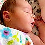 Madison is registered to the contest to win money with this photo: baby, sleeping, blanket, floral_pattern, infant, peaceful, cute, child, soft_skin, closeup, resting, indoors, portrait, newborn, wrapped, colorful, cozy, face, arm, quiet