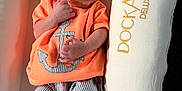 Gannan is registered to the contest to win money with this photo: newborn, baby, sleeping, orange_shirt, anchor_design, striped_shorts, baby_lounger, dockatot, deluxe, cushion, infant, peaceful, soft_light, relaxing, indoor, clothing, footwear, person, portrait, sleep