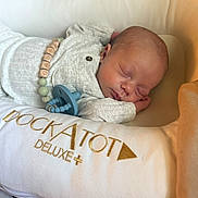 Gannan is registered to the contest to win money with this photo: baby, newborn, sleeping, pacifier, dockatot, deluxe, cushion, infant, soft, cozy, resting, child, clothing, bed, closeup, peaceful, portrait, indoors, cute, relaxing
