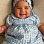baby, child, smiling, curly_hair, headband, blue_dress, checkered_pattern, sitting, couch, texture, happy, infant, portrait, indoors, cute, fashion, young, person, skin, face