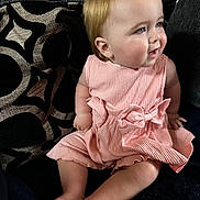 Mollie joined the competition — help win amazing prizes! baby, pink_dress, bows, couch, cushion, patterned_cushion, child, indoor, seated, smiling, legs, barefoot, furniture, person, cute, portrait, plush, soft_lighting, happy, skin