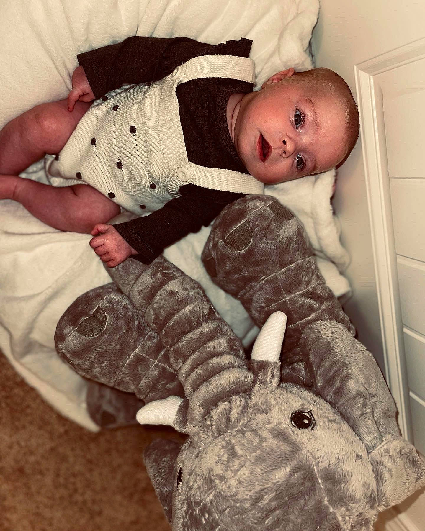 Parish is registered to the contest to win money with this photo: baby, baby_products, baby_safety, baby_sleeping, baby_toddler_clothing, cabinetry, child, comfort, door, hare, human_body, linens, pattern, person, rabbit, sitting, skin, sleeve, textile, toddler