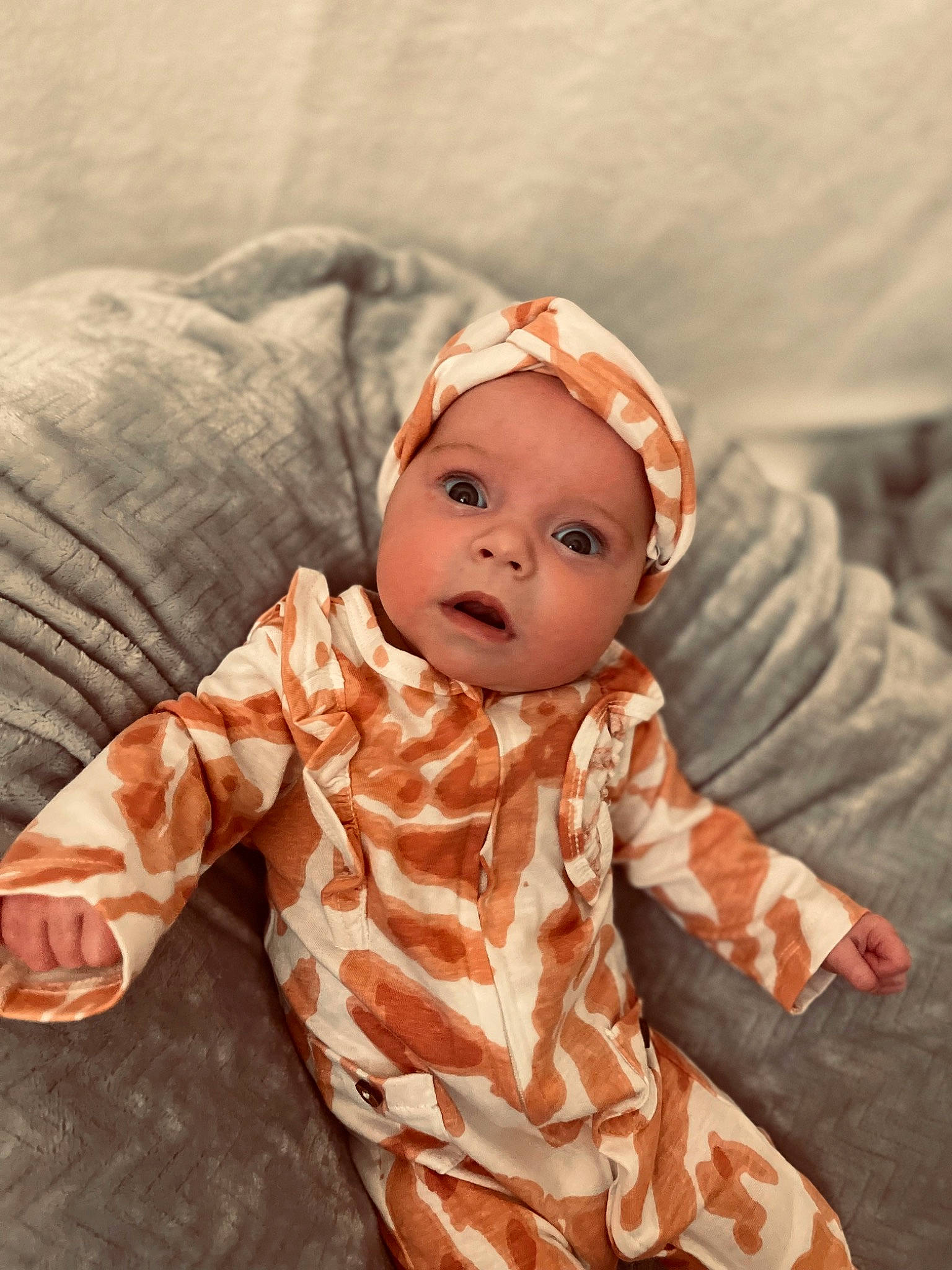 Parish is registered to the contest to win money with this photo: baby, baby_toddler_clothing, cheek, child, comfort, fur, happy, headgear, headwear, linens, orange, pattern, peach, person, portrait_photography, room, sitting, sleeve, toddler, toy