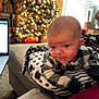 baby, black_and_white, blinds, child, christmas_tree, cozy, cushion, decorations, face, festive, furniture, holiday_lights, indoor, infant, laptop, living_room, patterned_clothing, person, polka_dot, window