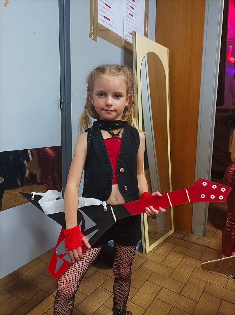 Augusta participe au concours pour gagner de l'argent avec cette photo : carmine, chair, event, fashion_design, fictional_character, flooring, fun, human_leg, knee, pattern, person, personal_protective_equipment, room, sitting, sock, sportswear, stocking, thigh, tie, uniform