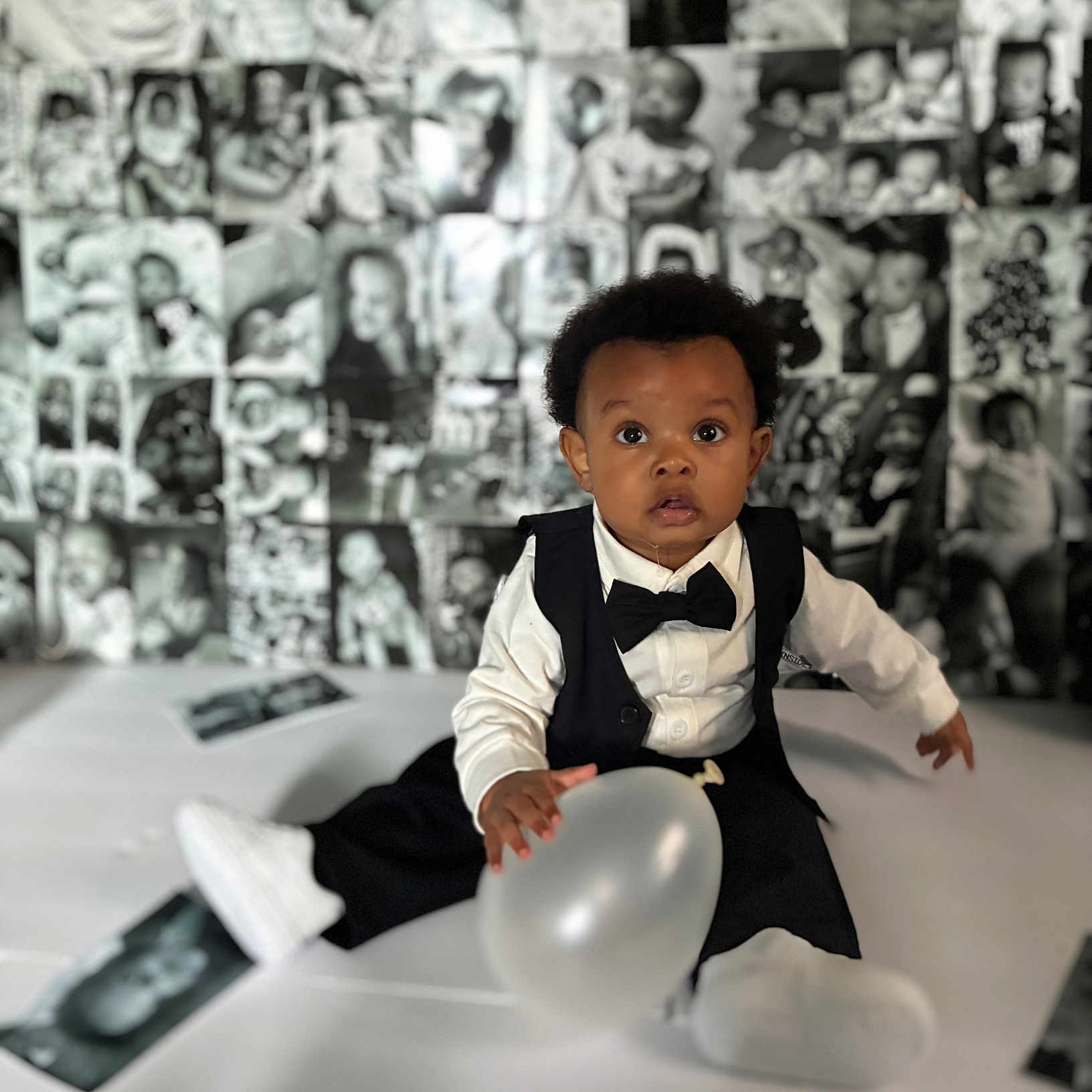 Kyleon is registered to the contest to win money with this photo: baby, tuxedo, balloon, black_and_white, portrait, child, infant, cute, formal_wear, sitting, photography, background, collage, monochrome, expression, face, clothing, indoor, person, young