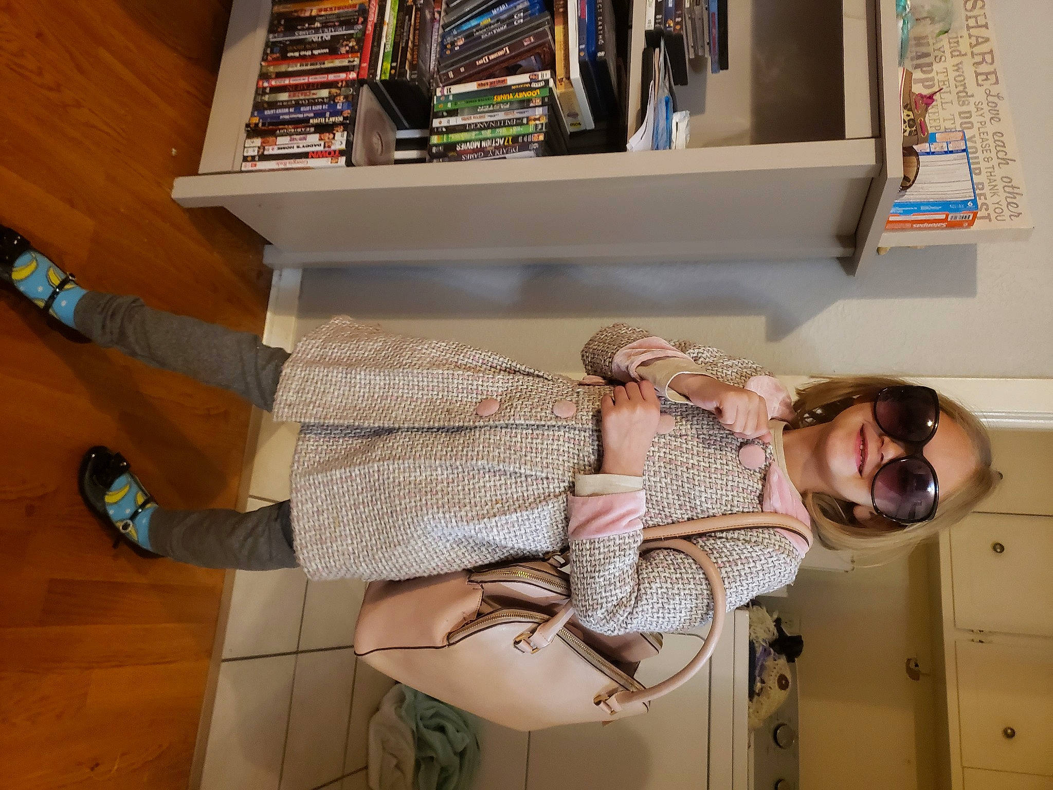 Braylee is registered to the contest to win money with this photo: ankle, book, bookcase, collection, cool, foot, human_leg, joy, laminate_flooring, outdoor_shoe, person, publication, shelf, shelving, shoe, sneakers, sock, sunglasses, sweater, walking_shoe