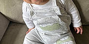 Harrison is registered to the contest to win money with this photo: baby, child, smiling, blue_eyes, overalls, socks, couch, indoor, happy, cute, infant, clothing, person, sitting, face, portrait, cozy, soft, comfortable, young
