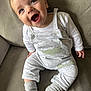 baby, child, smiling, blue_eyes, overalls, socks, couch, indoor, happy, cute, infant, clothing, person, sitting, face, portrait, cozy, soft, comfortable, young