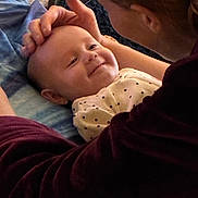 Elisia is registered to the contest to win money with this photo: baby, adult, smile, face, hand, indoor, cozy, blanket, clothing, person, head, touch, comfort, affection, closeup, portrait, interaction, happy, caring, skin