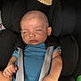 baby, car_seat, child, sleeping, blue_shirt, straps, infant, seat_belt, headrest, hand, diaper, black_cushion, soft_cloth, peaceful, indoors, portrait, young_child, resting, close_up, person