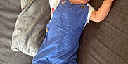 Joud a rejoint le concours — aidez-le/la à gagner de superbes lots ! baby, sleeping, blue_overalls, couch, pillow, arm_stretched, barefoot, infant, relaxed, indoors, child, face, peaceful, rest, comfort, toddler, clothing, furniture, home, portrait