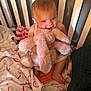 baby, child, crib, toy, plush, bunny, blanket, smile, happy, indoor, person, cute, soft, furniture, infant, toddler, baby_clothing, colorful, comfort, playful
