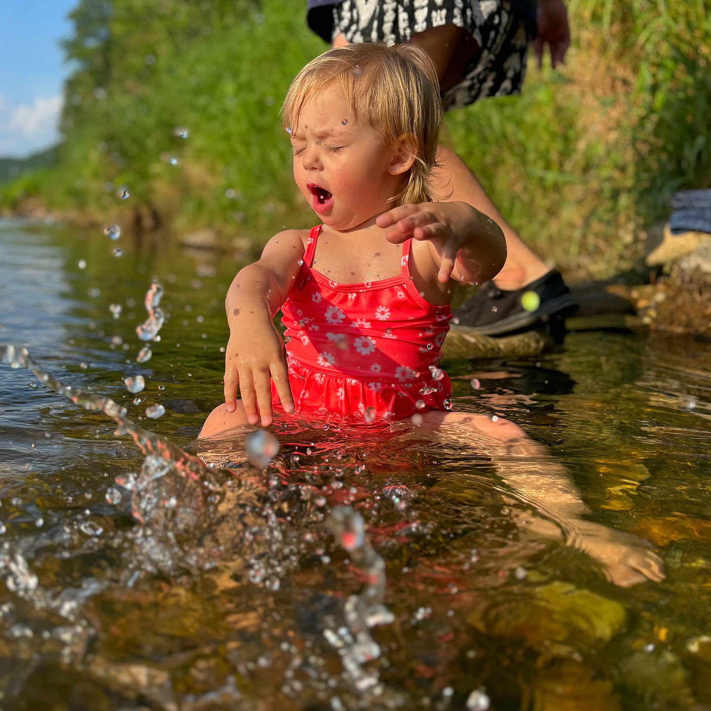 Dayna is registered to the contest to win money with this photo: adult, barefoot, child, creek, daytime, fun, grass, happy, nature, outdoor, person, play, river, splashing, summer, sunlight, swimsuit, toddler, water, water_droplets