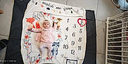 Eléna participe au concours pour gagner de l'argent avec cette photo : baby, baby_clothes, blanket, crib, cute, deer, floor_tile, flower, fox, headband, home_interior, infant, laying_down, llama, milestone, milestone_blanket, numbers, raccoon, red_heart, striped_tights