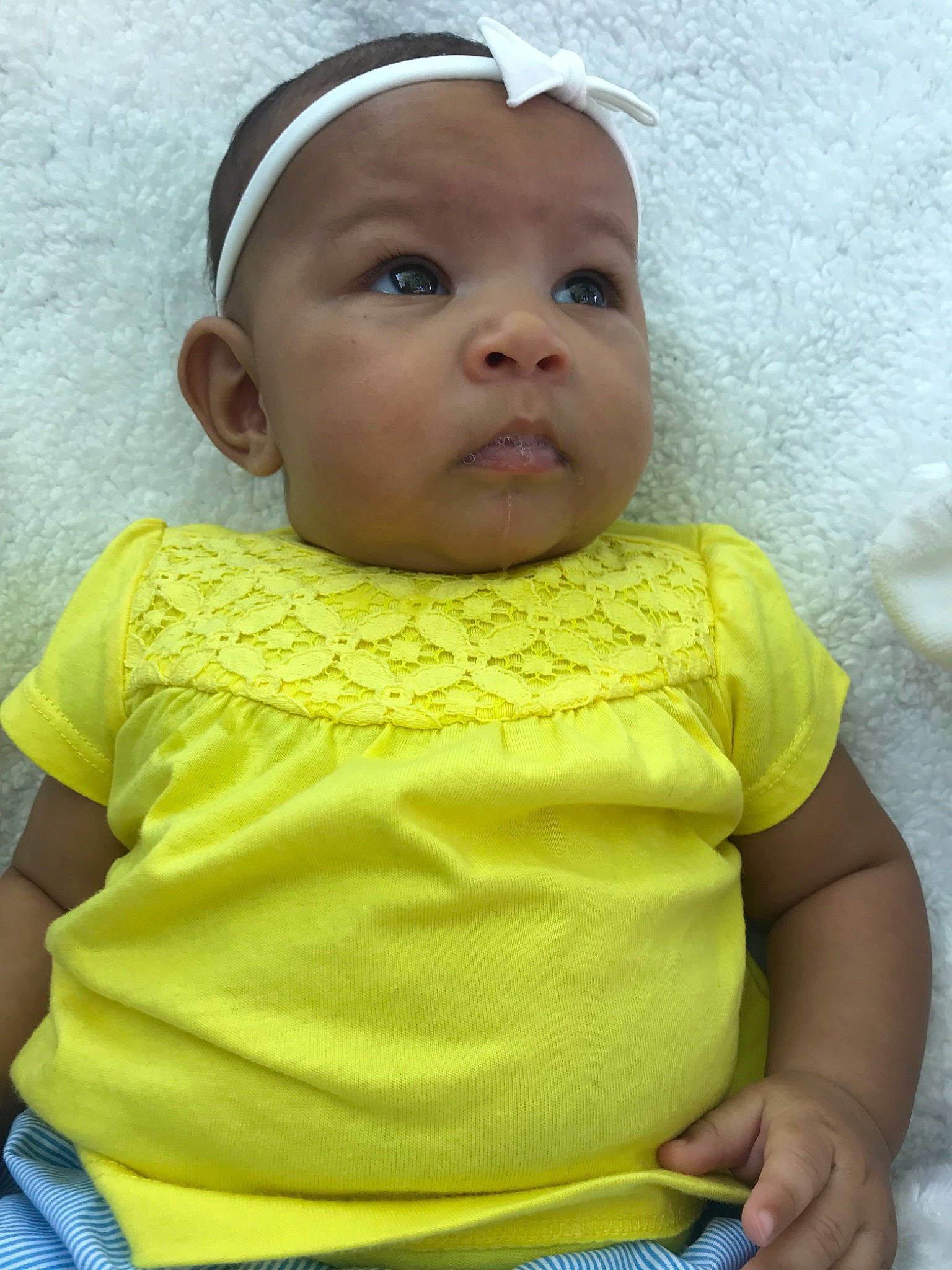 Lyanna is registered to the contest to win money with this photo: baby, baby_products, baby_toddler_clothing, cheek, child, hair_accessory, headband, headgear, headwear, person, skin, smile, toddler, yellow