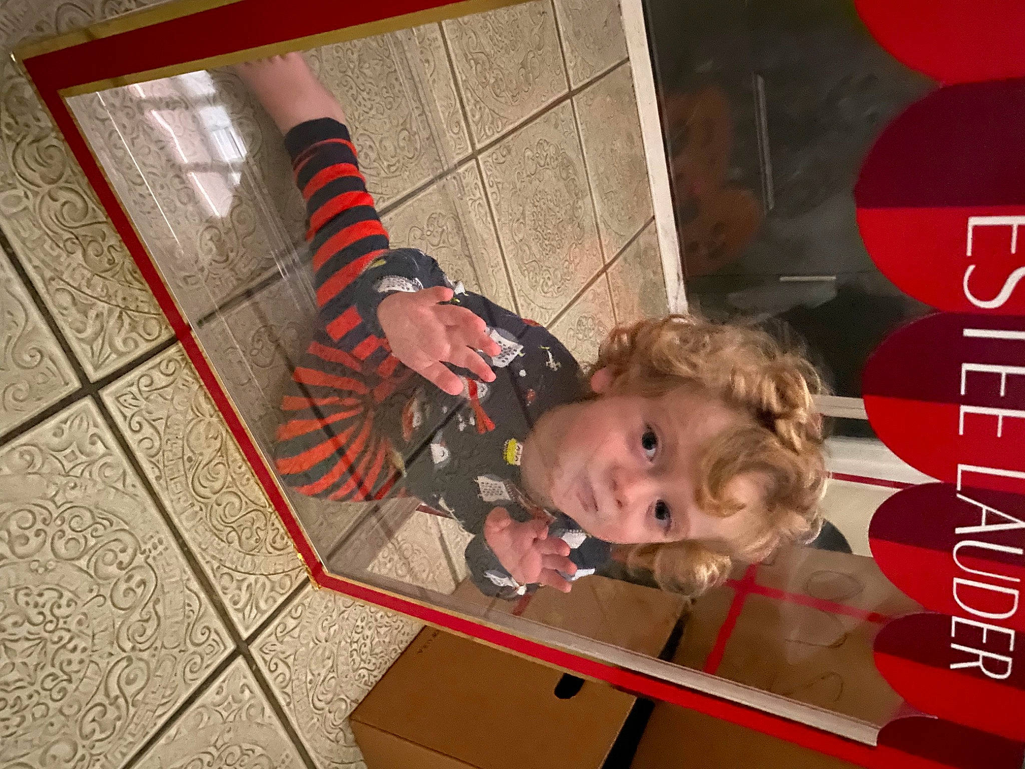 Leo is registered to the contest to win money with this photo: child, flooring, fun, happy, human_leg, pattern, person, photo_caption, red, room, toddler, wood