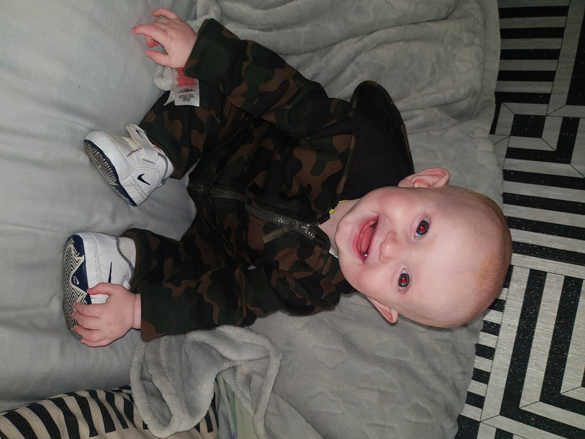 Kelvin is registered to the contest to win money with this photo: baby, baby_products, baby_toddler_clothing, cheek, child, comfort, eye, finger, flooring, fun, hairstyle, hand, joy, mammal, mouth, person, sitting, skin, sleeve, smile