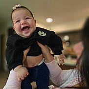 Sophia Grace Leon is registered to the contest to win money with this photo: adult, baby, being_held, black_clothing, child, close_up, family, hair_bow, hands, happy, home, indoor, infant, joyful, laughing, long_sleeves, parent, photography, portrait, smiling