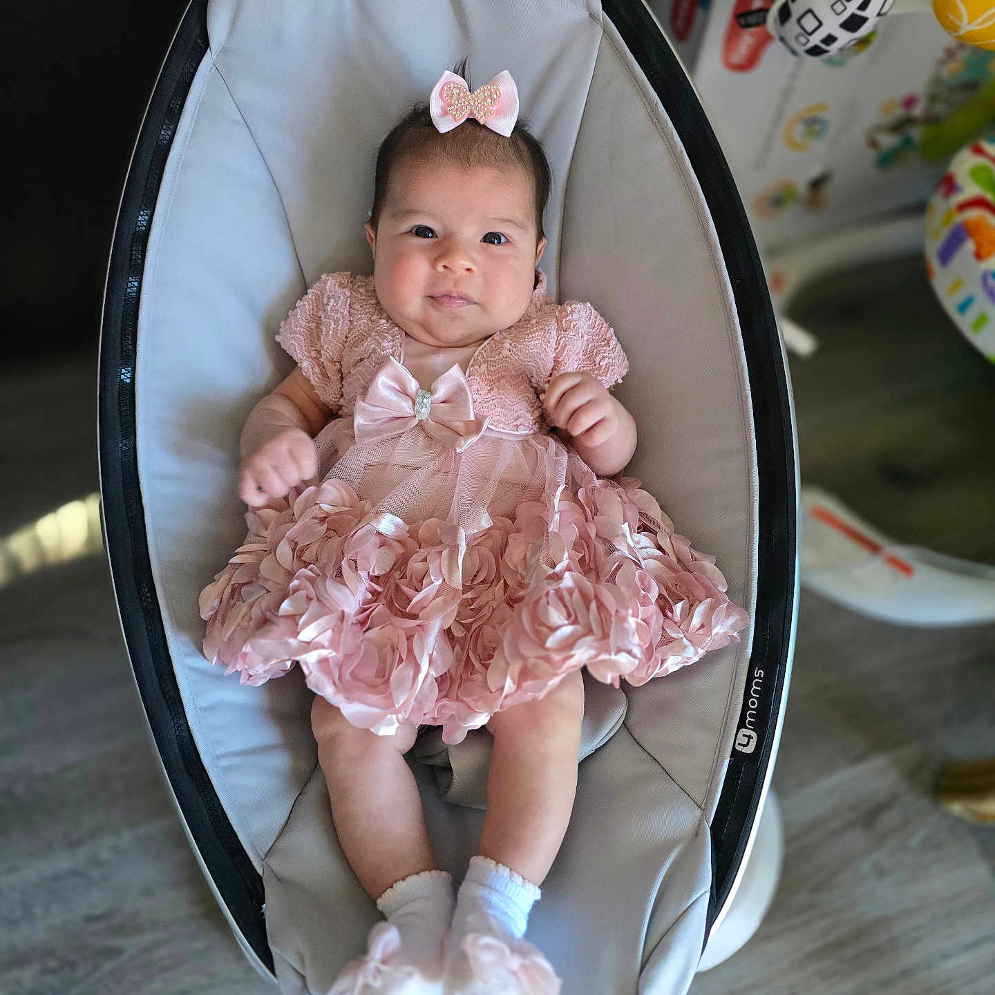Sophia Grace Leon joined the competition — help win amazing prizes! baby, infant, child, pink_dress, bow, baby_rocker, socks, footwear, cute, smiling, indoor, flooring, modern_furniture, baby_toy, portrait, person, seated, happy, clothing, home