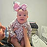 Sophia Grace Leon is registered to the contest to win money with this photo: adult, baby, baby_bouncer, child, crib, family, floral_onesie, hands, happy, headband, home, indoor, infant, nursery, onesie, person, pink_bow, portrait, sitting, smiling
