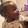 Gerzi is registered to the contest to win money with this photo: baby, smiling, indoor, onesie, pacifier_clip, child, pigtails, face, happy, infant, furniture, dresser, room, person, cute, closeup, portrait, clothing, skin, young