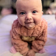 Ivy is registered to the contest to win money with this photo: baby, bed, blanket, blue_eyes, child, cozy, crawling, cute, face, hands, happy, head, indoors, infant, person, pink_sweater, portrait, smiling, soft_texture, young_child