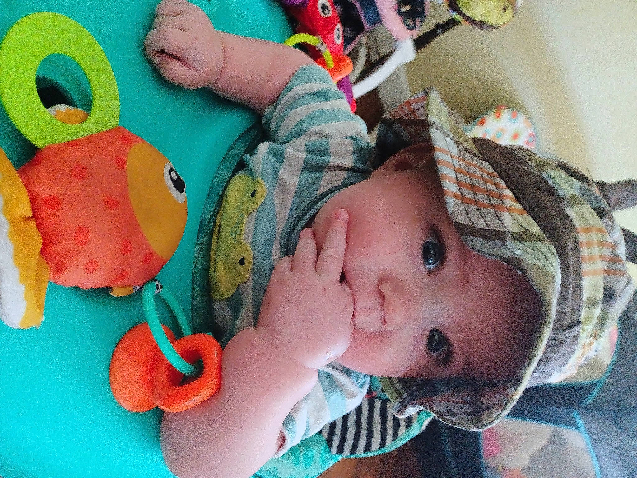 Elijah is registered to the contest to win money with this photo: arm, baby, baby_playing_with_toys, baby_products, baby_toddler_clothing, cheek, child, comfort, facial_expression, finger, fun, green, happy, headgear, headwear, mouth, nose, person, skin, toddler