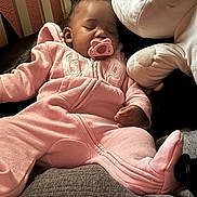 Kamrynn joined the competition — help win amazing prizes! baby, sleeping, pacifier, pink_onesie, plush_toy, soft_toys, indoor, child, cute, relaxed, cozy, infant, resting, furniture, home, portrait, young_child, peaceful, cuddling, sleep