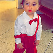 Adam participe au concours pour gagner de l'argent avec cette photo : toddler, child, indoor, barefoot, red_pants, white_shirt, bow_tie, suspenders, floor, tiles, curious, standing, person, young_child, clothing, portrait, cute, baby, face, expression