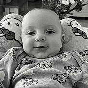 Lukas participe au concours pour gagner de l'argent avec cette photo : baby, infant, smiling, onesie, cartoon_pattern, plush_cushion, hello_kitty, face, indoor, furniture, flowers, cozy, portrait, child, cute, closeup, home, soft_toys, black_and_white, happy